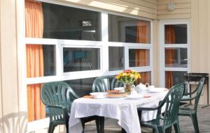 ein Tisch auf einer Veranda mit Stühlen und Blumen darauf in der Unterkunft Friedrichskoog-strandpark 10 in Friedrichskoog