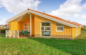 ein gelbes winziges Haus mit einem Hof in der Unterkunft Friedrichskoog-strandpark 8 in Friedrichskoog