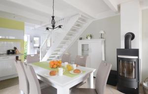 a white dining room with a table with fruit on it at Haus Seeadler 5 in Süssau