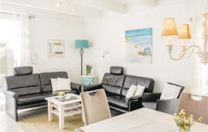 a living room with black leather furniture and a table at Haus Seeadler 5 in Süssau