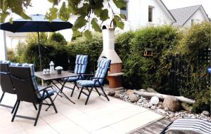 a patio with a table and chairs and an outdoor grill at Haus Seeadler 5 in Süssau