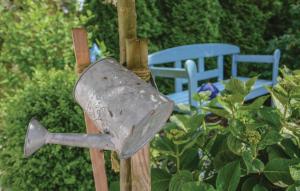 a bird feeder on a pole with two blue chairs at Haus Seeadler 5 in Süssau +31 photos