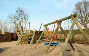 a playground with two swings in the sand at Haus Seeadler 5 in Süssau