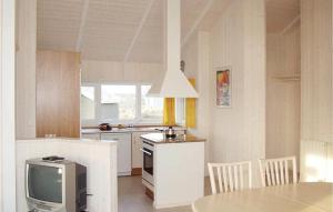 腓特烈斯科格Friedrichskoog-Strandpark 14的一间厨房,内设桌子和一台电视机