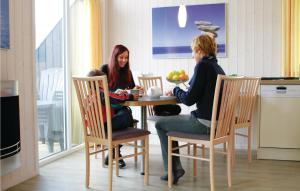 two women sitting at a table in a kitchen at Friedrichskoog-Deichblick 18 in Friedrichskoog