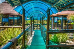 a blue roofed walkway leading to a building at Poa Place Resort & Hotel - Where Nature Meets Comfort Eldoret in Eldoret +17 photos