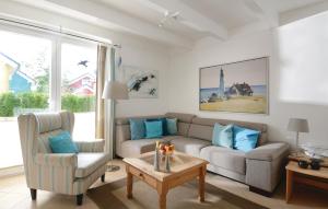 a living room with a couch and a chair and a table at Haus Seeadler 1 in Süssau