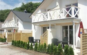 a white house with a wooden fence and chairs at Haus Seeadler 1 in Süssau