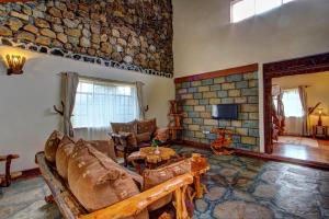 uma sala de estar com um sofá e uma parede de pedra em Naivasha Kongoni Lodge - Lakefront Getaway em Naivasha