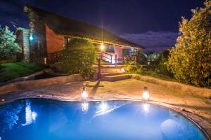 a swimming pool in front of a house at night at Naivasha Kongoni Lodge in Naivasha