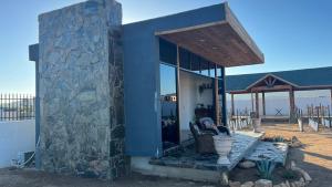 une maison avec un mur en pierre et une terrasse couverte dans l'établissement HACIENDA 7 AMORES, à El Porvenir