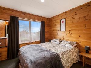 1 dormitorio con cama y ventana grande en Lakewood - Omori Holiday Home en Kuratau