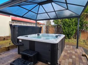 a hot tub under an umbrella on a patio at The Nash - National Park Holiday Home in National Park