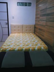 Casa Inteira aconchegante com garagem Próximo ao Aeroporto في لورو دي فريتاس: غرفة نوم مع سرير مع لحاف متهالك