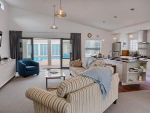 ein Wohnzimmer mit 2 Sofas und einer Küche in der Unterkunft Poolside Retreat - Picton Holiday House Waikawa in Picton + 12 Fotos