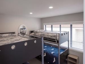 ein Schlafzimmer mit zwei Etagenbetten und einem Fenster in der Unterkunft Poolside Retreat - Picton Holiday House Waikawa in Picton