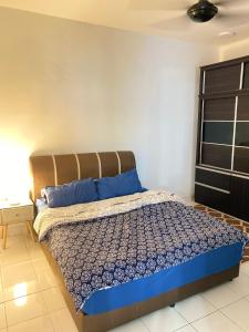 a bedroom with a bed with blue pillows at i-Idaman Kota Puteri Homestay and Free WIFI in Batu Arang