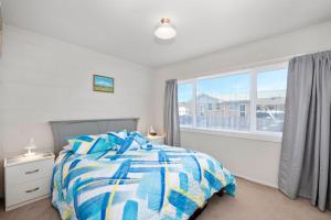 a bedroom with a bed and a large window at Central Stay - Taupo Flat in Taupo