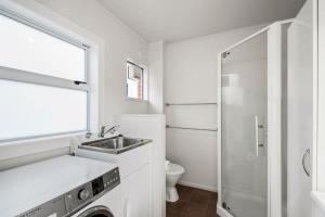 タウポにあるCentral Stay - Taupo Flatの白いバスルーム(洗面台、トイレ付)