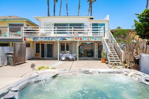 a swimming pool in front of a house at BEACHFRONT COTTAGE LOWER UNIT in Oceanside