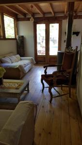 Cabaña Lodge los Coihues VALLE LAS TRANCAS# TERMAS DE CHILLAN#NEVADOS DE CHILLAN في Pinto: غرفة معيشة مع أريكة وسرير وكرسي