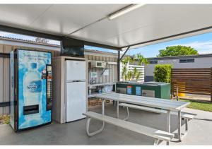 a picnic table with a drink dispenser and a refrigerator at Discovery Parks - Blackwater in Blackwater