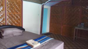 a bedroom with a bed with a towel on it at Diara bungalow in Iboih