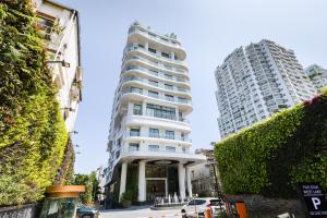 a tall white building with two tall buildings at Five Star Westlake 1st-4th Floors Hotel & Serviced Apartment in Hanoi