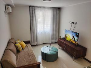 uma sala de estar com um sofá e uma televisão em Apartamento Carlos Paz em Villa Carlos Paz