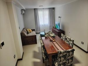 salon z drewnianym stołem i krzesłami w obiekcie Apartamento Carlos Paz w mieście Villa Carlos Paz