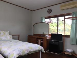 sypialnia z łóżkiem i komodą z lustrem w obiekcie Guesthouse Yui w mieście Hongu