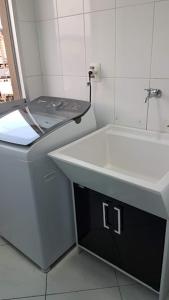 a white bathroom with a sink and a toilet at QUARTO TOP no CENTR0 com Cama Box de casal - acomoda até 2 pessoas - Home Office - WIFI - Smart TV com Apps Youtube - Cozinha - banheiro - Sala de Estar - Apto compartilhado com Anfitriões experientes em hospedar - Superhost no BnB 5 estrelas in Criciúma