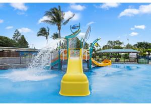 KinkaDiscovery Parks - Coolwaters, Yeppoon的一个带水上公园的游泳池的水滑梯