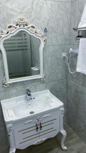 une salle de bain avec un lavabo blanc et un miroir dans l'établissement Qafqaz Fountain House, à Qabala