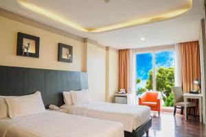 ASTON Bogor Hotel and Resort في بوغور: غرفة فندقية بسريرين ونافذة