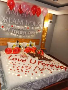 Una cama con un pastel con corazones y globos. en Anita dream house, en Khao Sok