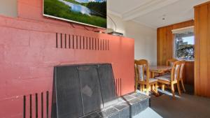 a living room with a red wall with a fireplace at 1750 Hotham 11 in Mount Hotham