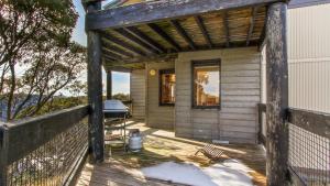 a wooden porch of a house with a grill at 1750 Hotham 11 in Mount Hotham