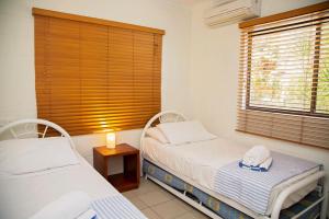 a bedroom with two beds and a window with a hat at Apollo Jewel Beachfront Apartments in South Mission Beach