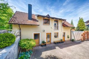 una pequeña casa con un patio frente a ella en Select-Home 1 - Wellnesshaus Sandmühle - mit privater Sauna en Bruck in der Oberpfalz