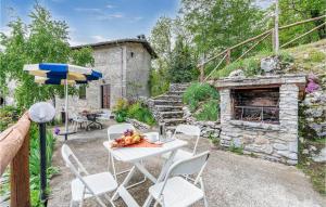 a patio with a table and chairs and a stone fireplace at Fornione in Fabbriche di Vallico