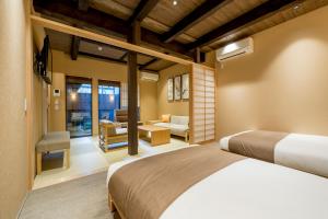a bedroom with two beds and a living room at RESI STAY NISHIKI in Kyoto