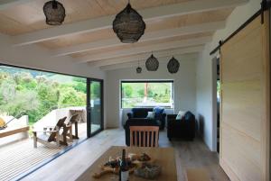 a living room with a table and a large window at Lake View Okareka - Lake Okareka Holiday Home in Lake Tarawera