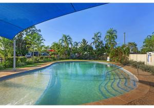 a large swimming pool with a blue umbrella at Discovery Parks - Darwin in Darwin