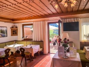 a restaurant with two tables and a balcony with people at Pension & Appartements Ronacherhof in Bad Kleinkirchheim