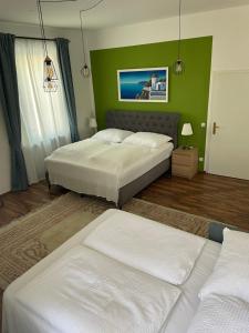 a bedroom with two beds and a green wall at Studios Klagenfurt in Klagenfurt