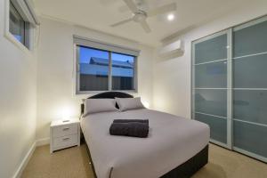een slaapkamer met een wit bed en een raam bij 108 Madaffari Drive in Exmouth
