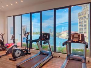 a gym with cardio machines in front of a large window at Netflix Two Bedroom Troika Kota Bharu Homestay 182 in Kota Bharu