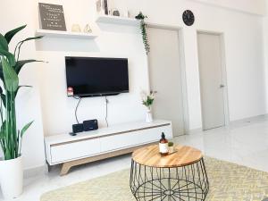 a living room with a tv on a white wall at #Netflix #Cuckoo Troika Kota Bharu Homestay 0182 in Kota Bharu