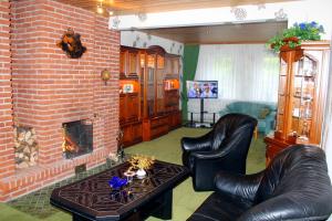 a living room with two leather chairs and a fireplace at Haus Veni in Bad Grund